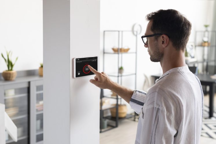 Homme utilisant un thermostats intelligents pour réduire les factures d'énergie